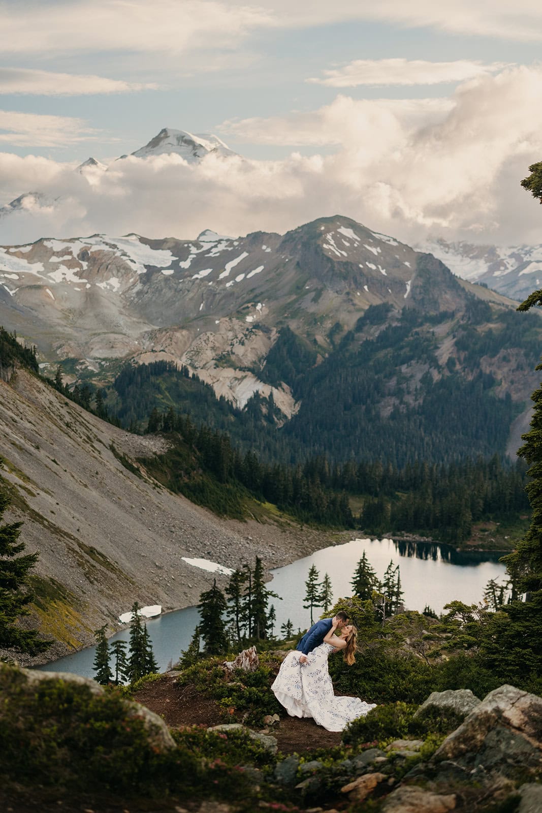 A couple shares a passionate deep kiss in the mountains.