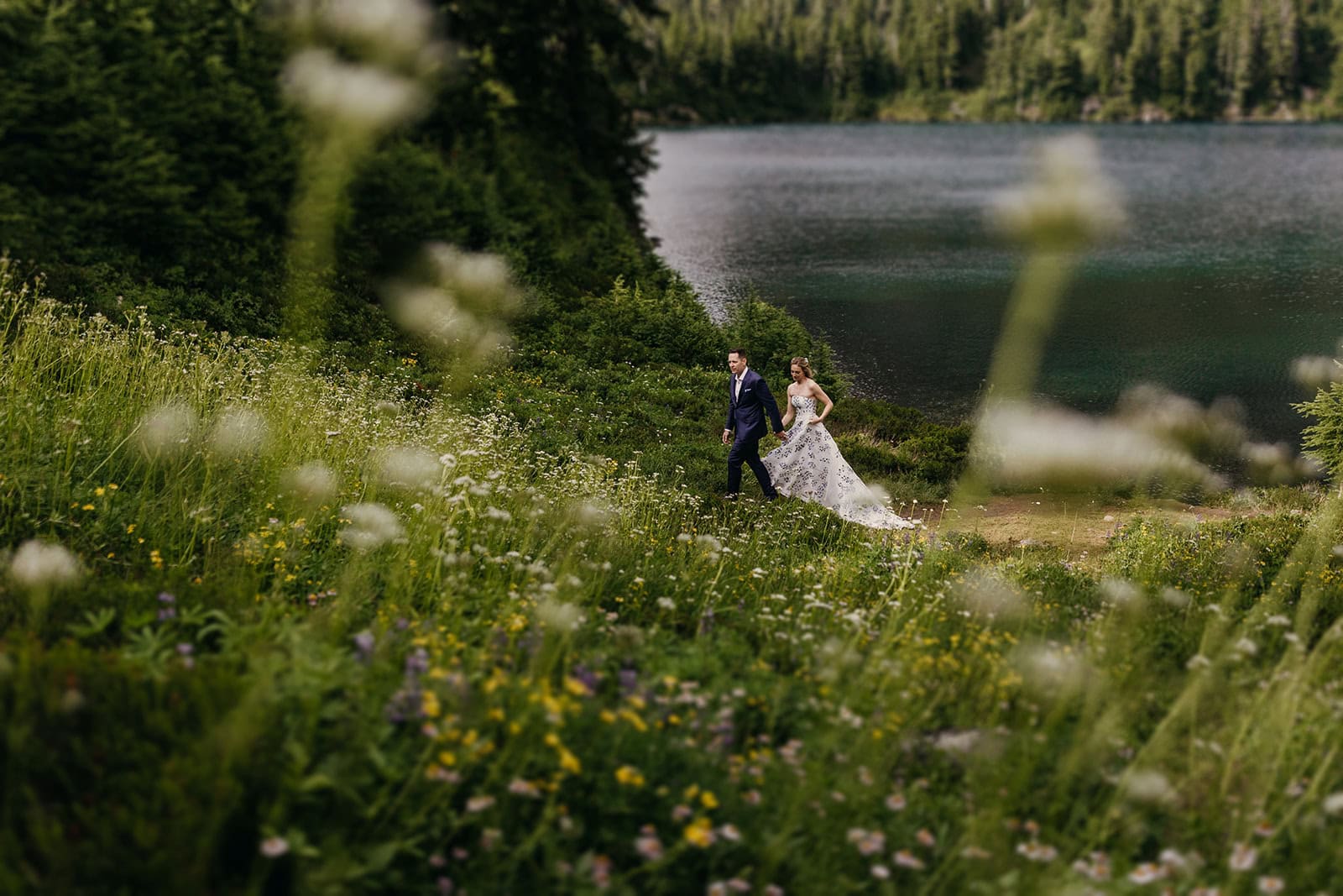 A couple hike in their wedding attire in Washington State.
