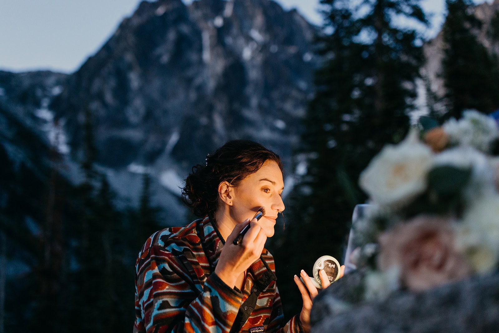 A bride doing her makeup at Colchuck lake during the early hours of the day.