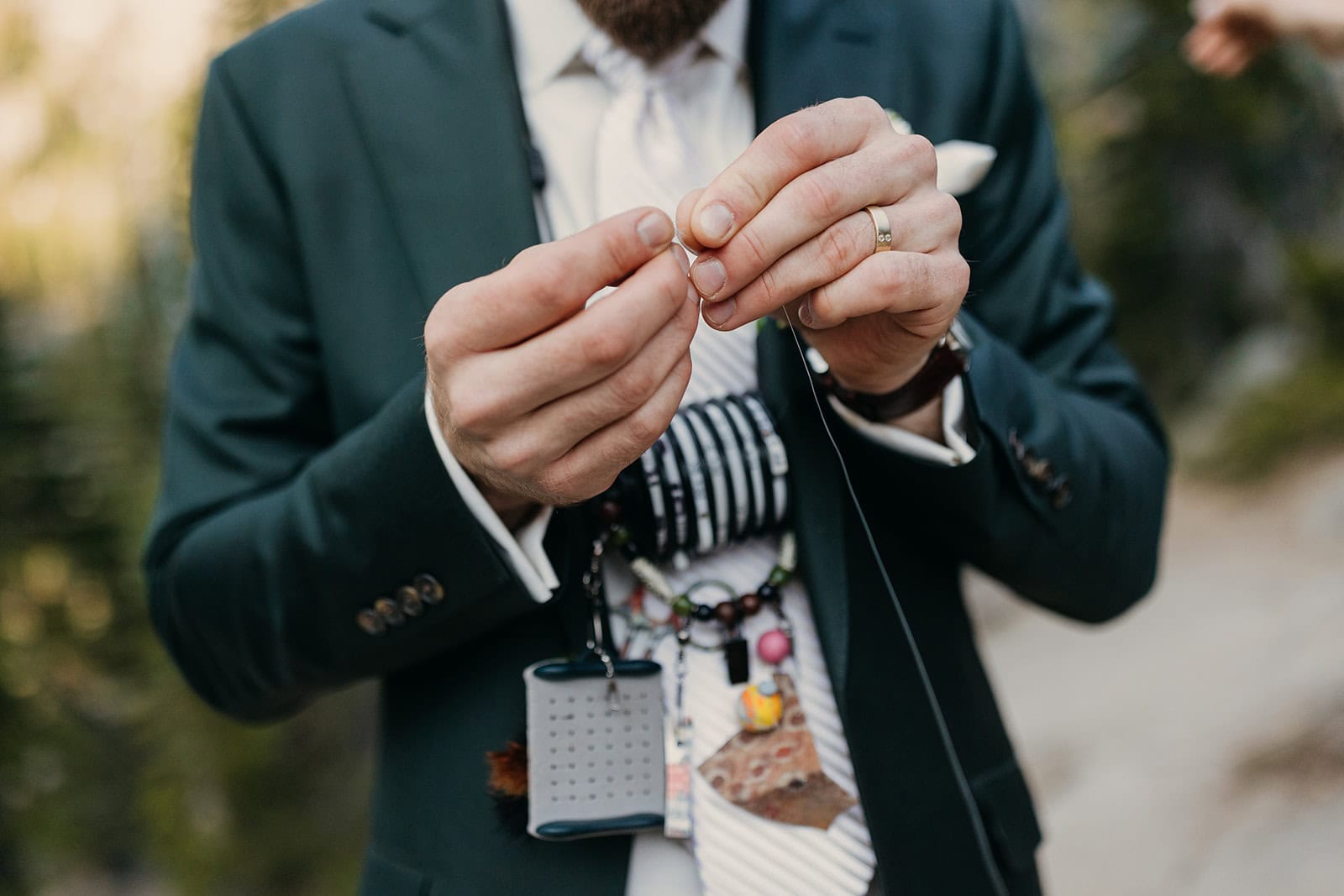 A man in a suit preparing a fishing line.