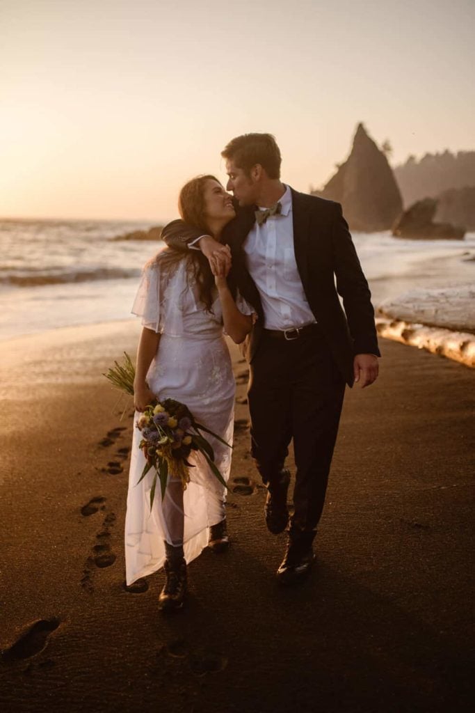 A couple walks along Rialto beach at sunset.