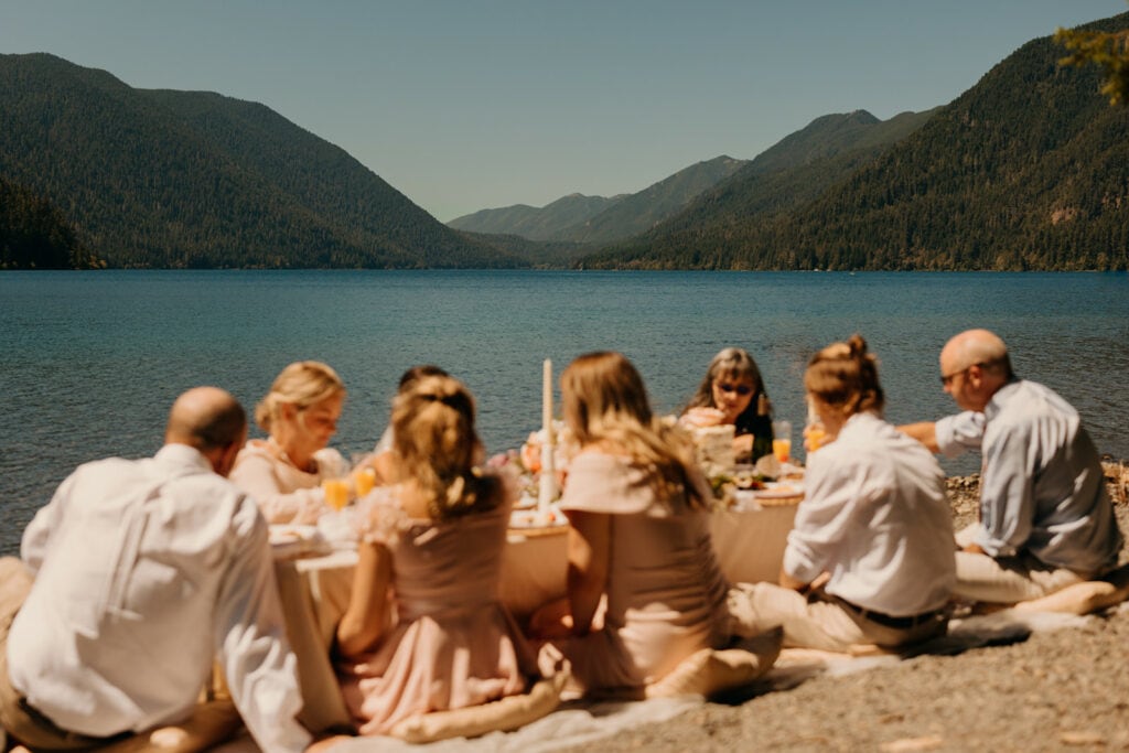 A family sits together at a picnic by lake crescent.