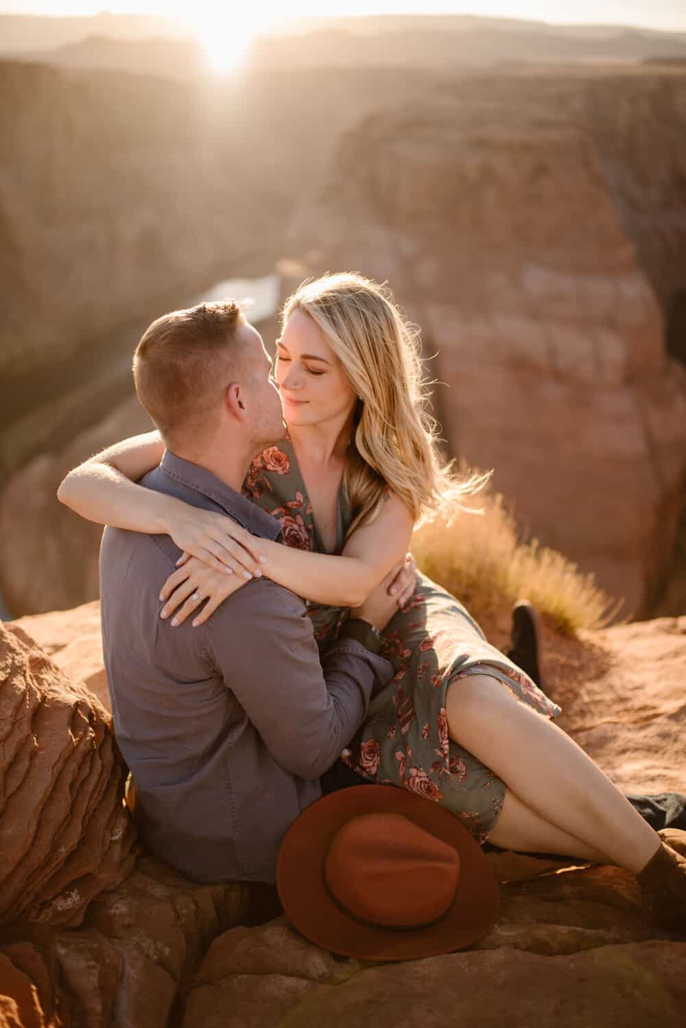 A woman looks into a mans eyes as they sit together at Horse shoe bend.
