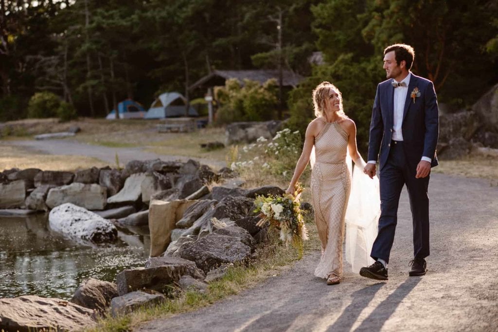 A couple walks down a path near their campsite towards their ceremony location.