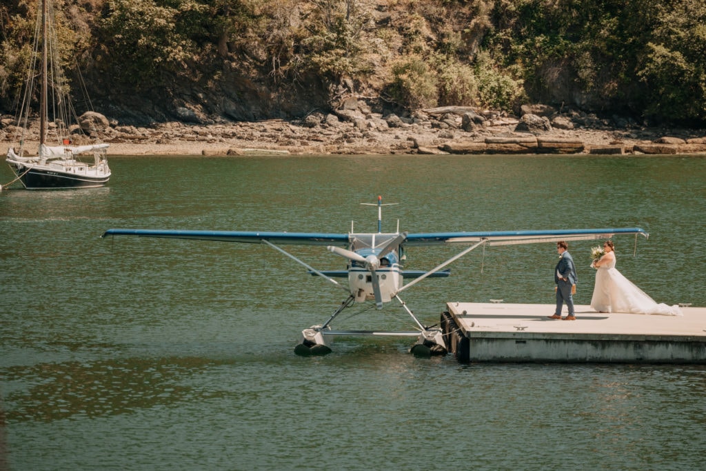 A bride and groom walking towards a sea plane.