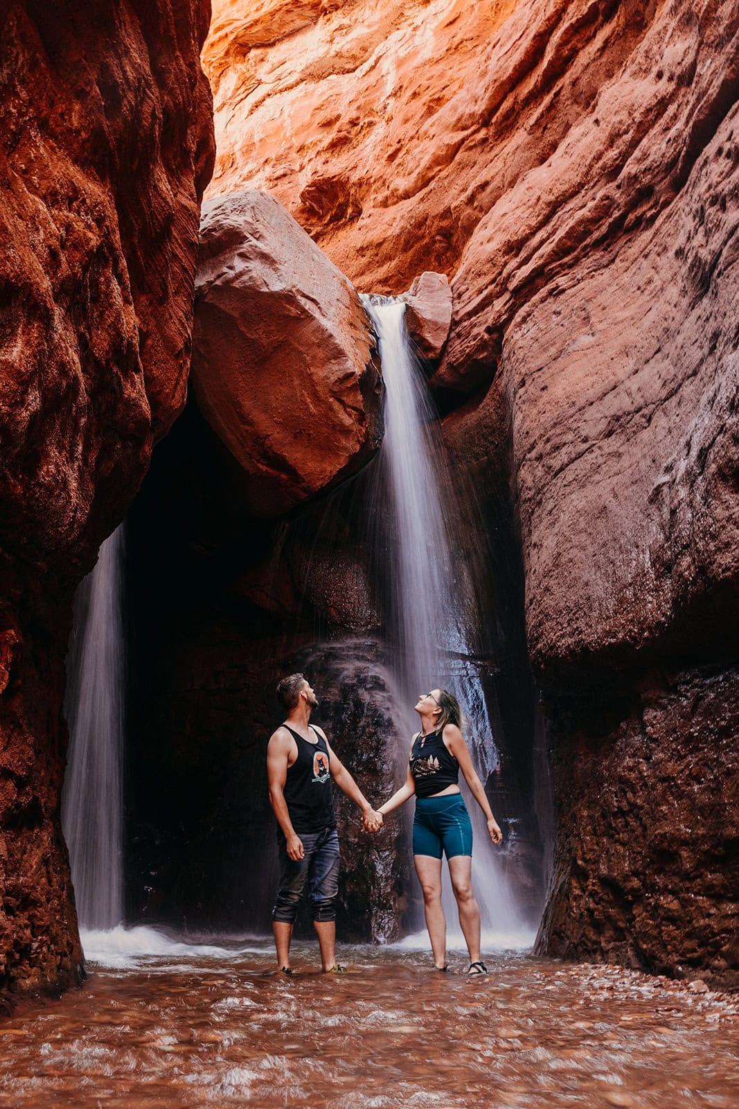A couple looking up at the waterfall at the end of Mary Jane Canyon.