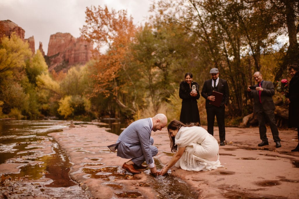 A couple washes a stone during their ceremony as a tradition of the bride's culture.