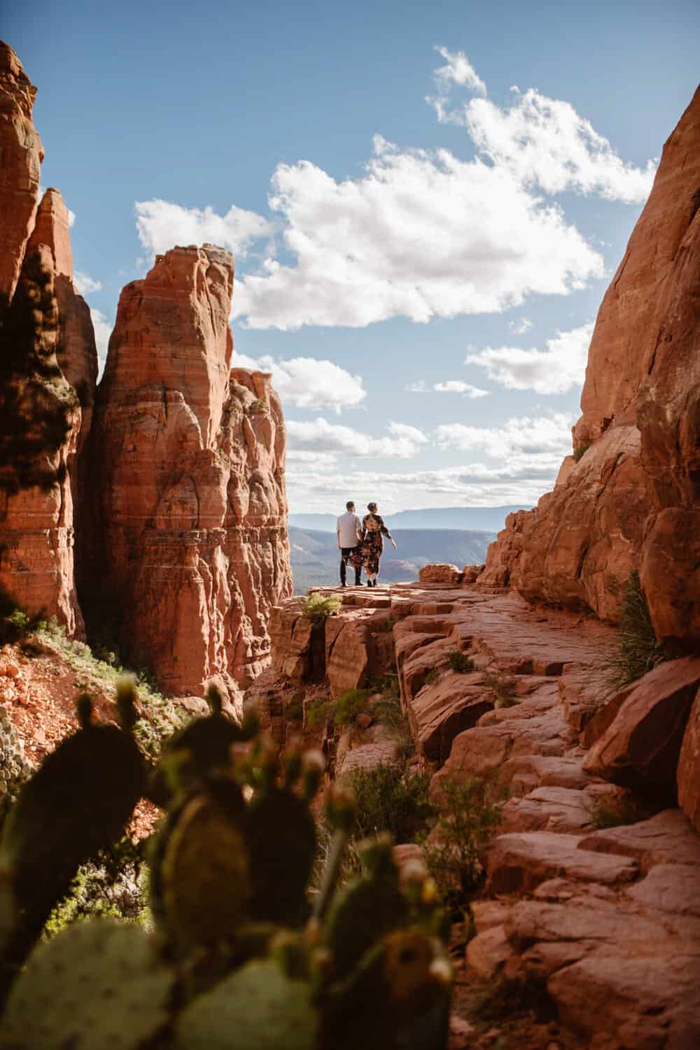 A couple stands at the top of Cathedral Rock together.