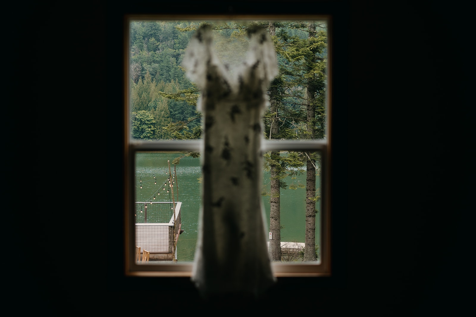 A detail photo of a dress hanging in a window at the venue.