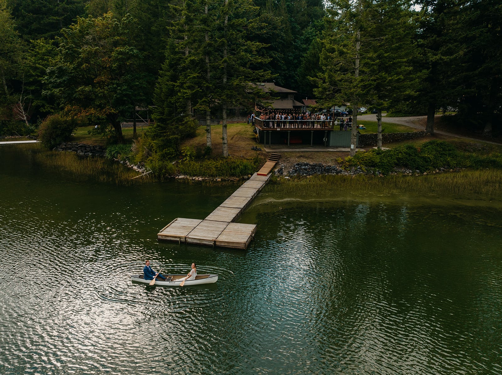 A couple canoes into their wedding venue.