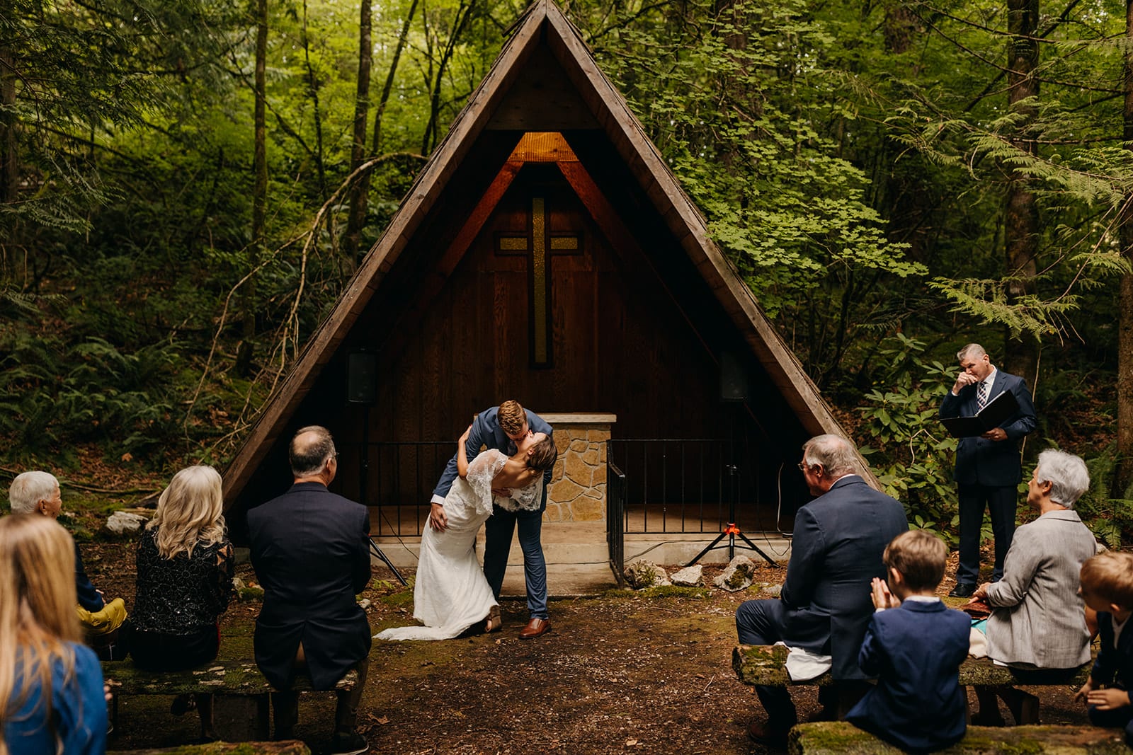 A groom dip kisses his bride at the alter.