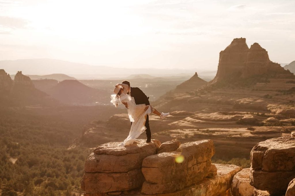 A groom dips his bride back for a kiss