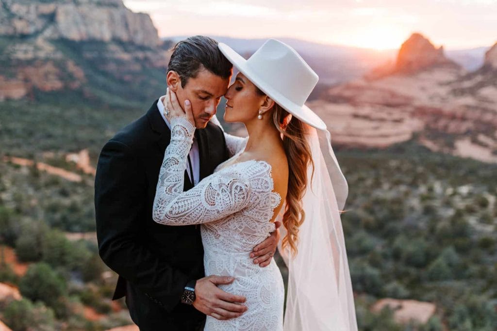 A bride and groom stand together at sunset in Sedona.