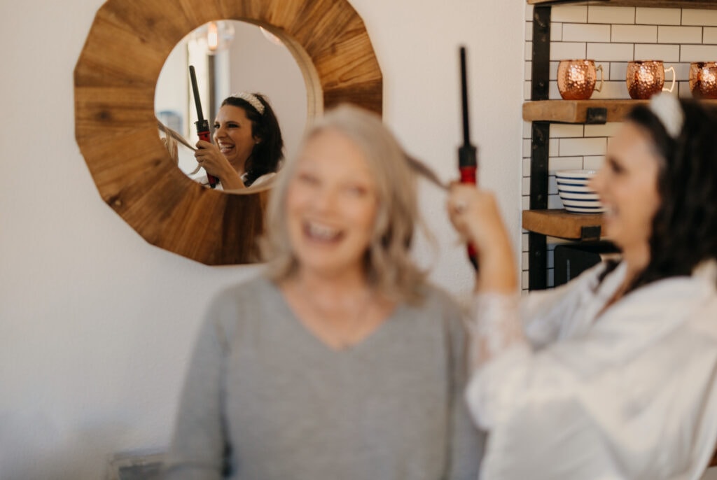 A bride does her mothers hair on her wedding day.