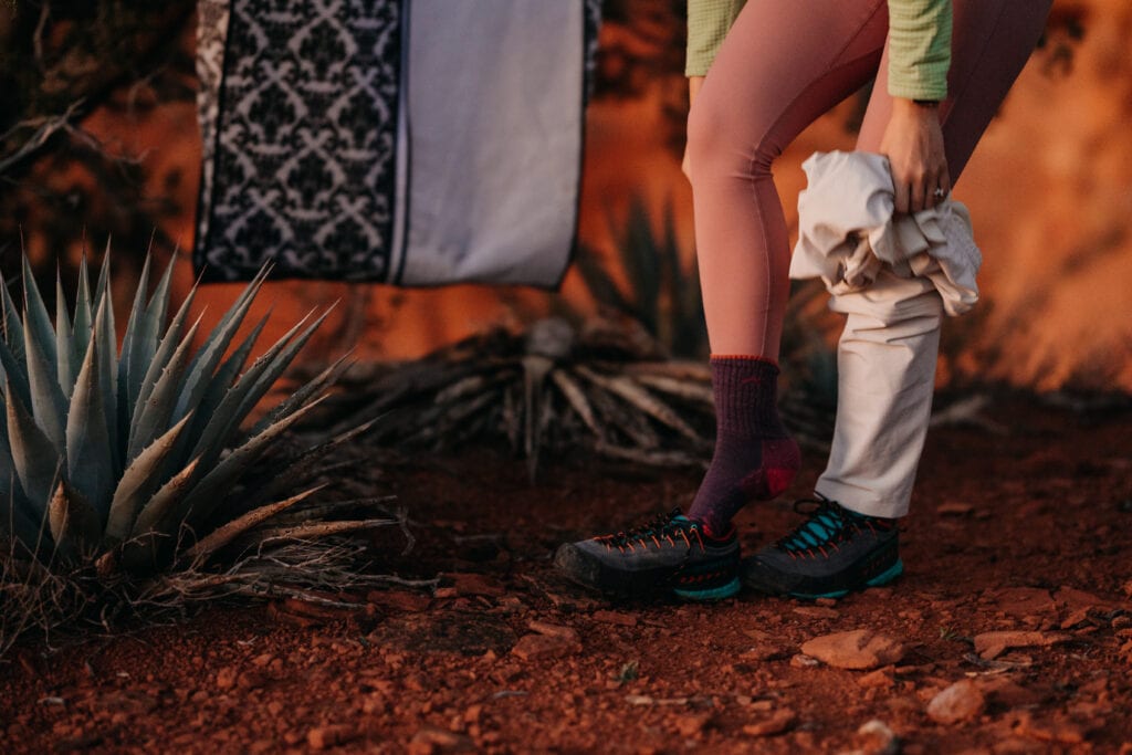 A bride begins putting on her wedding dress at sunrise