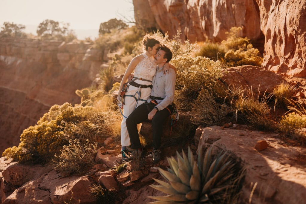 A bride and groom stand together at sunset for a portrait