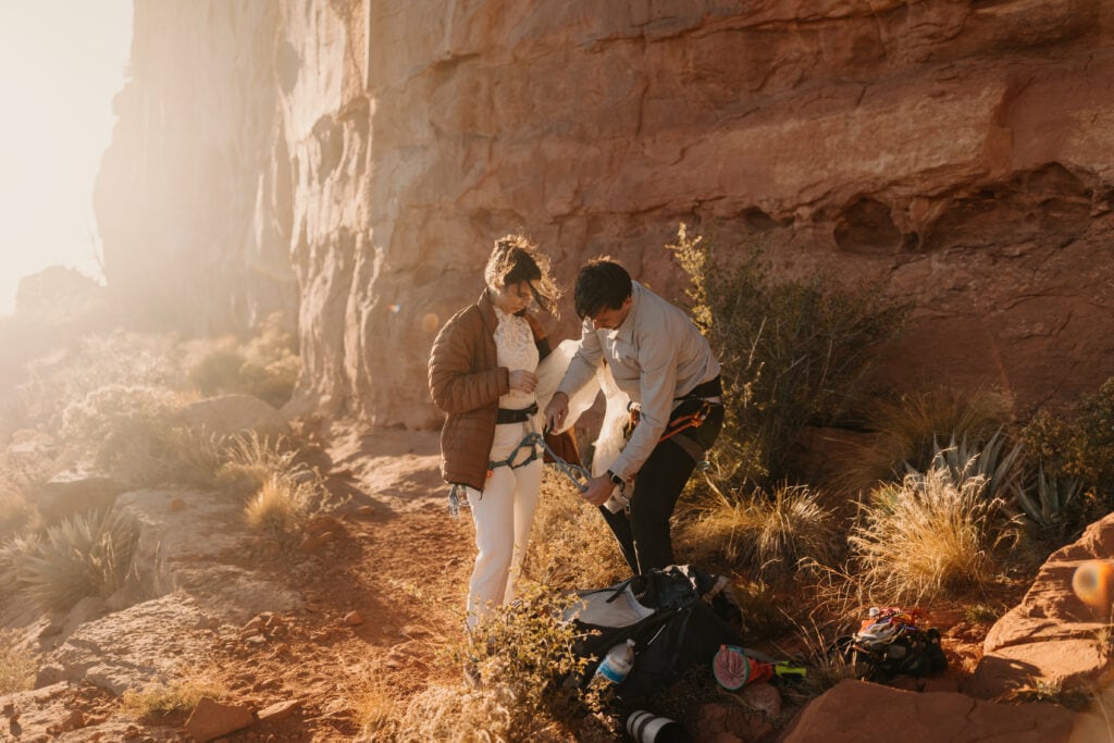 A bride and groom take their climbing gear off after finishing a climb in Sedona