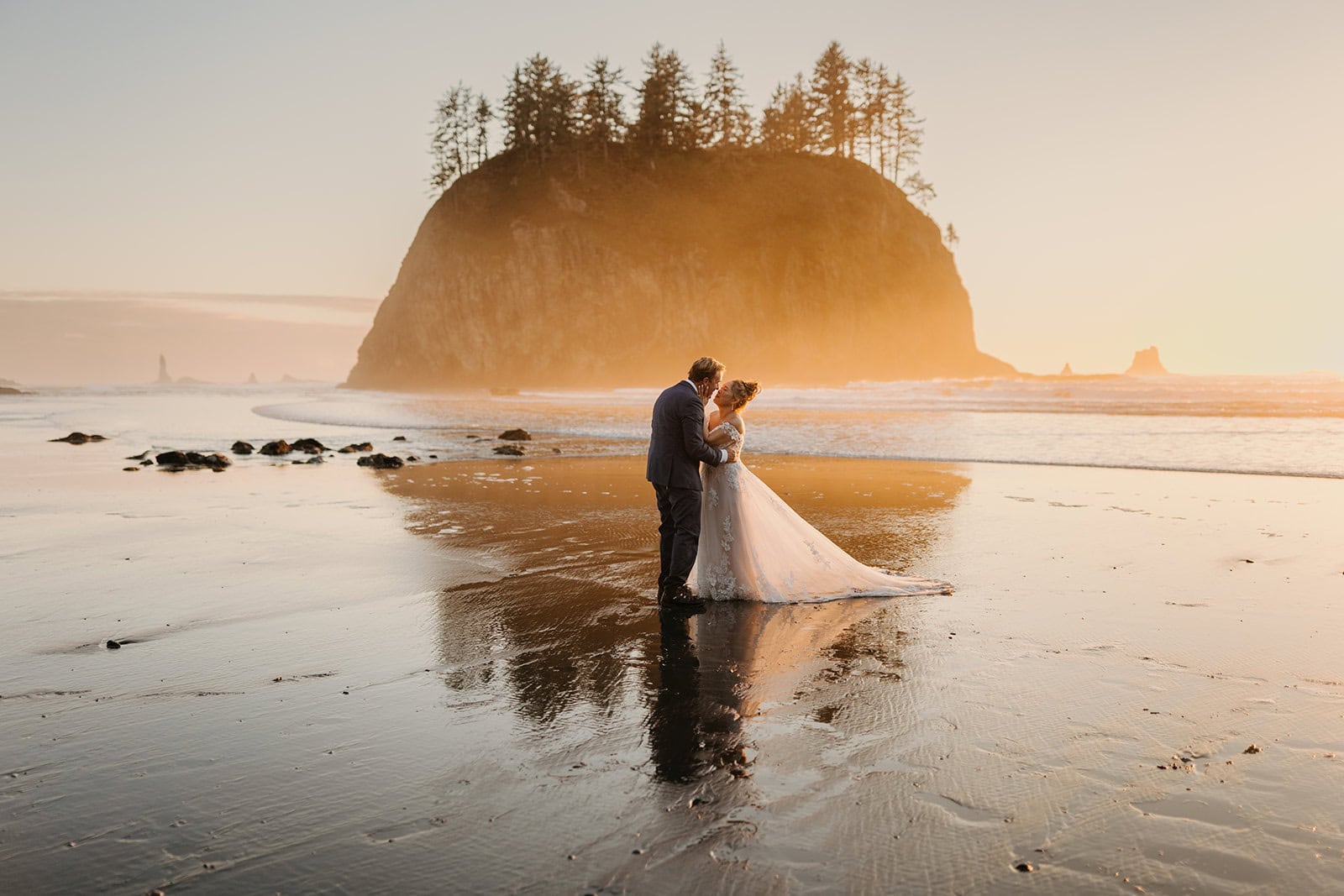 a couple shares a kiss at sunset in olympic national park