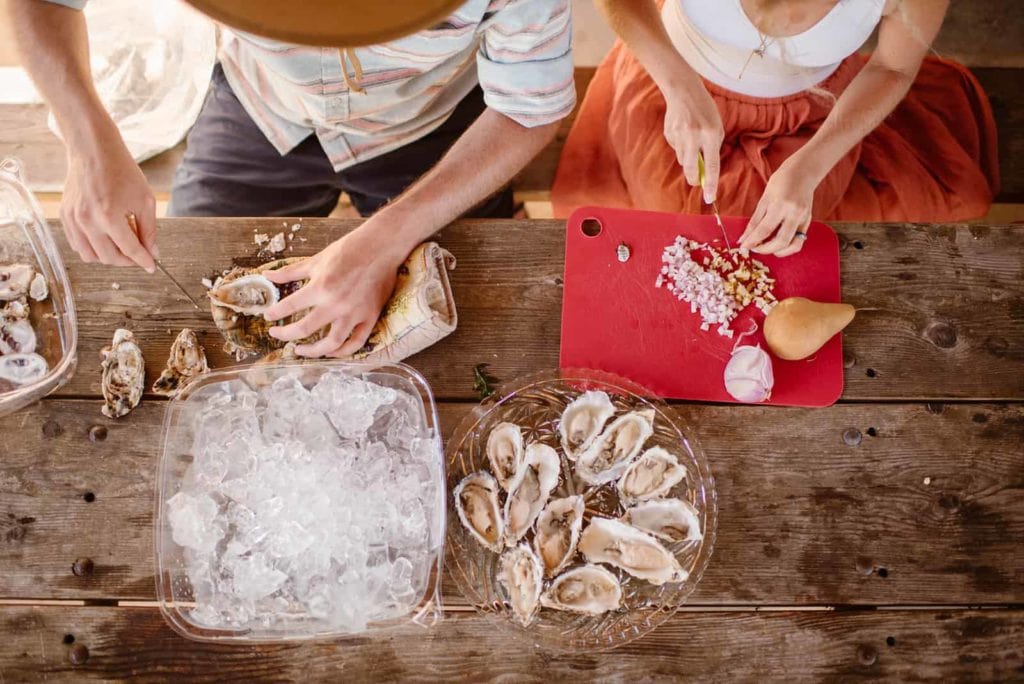 The couple makes oysters for dinner.