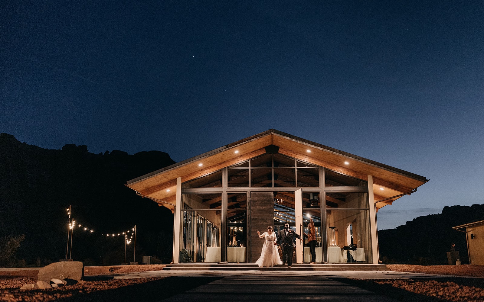 A couple leaves a venue at night after their reception