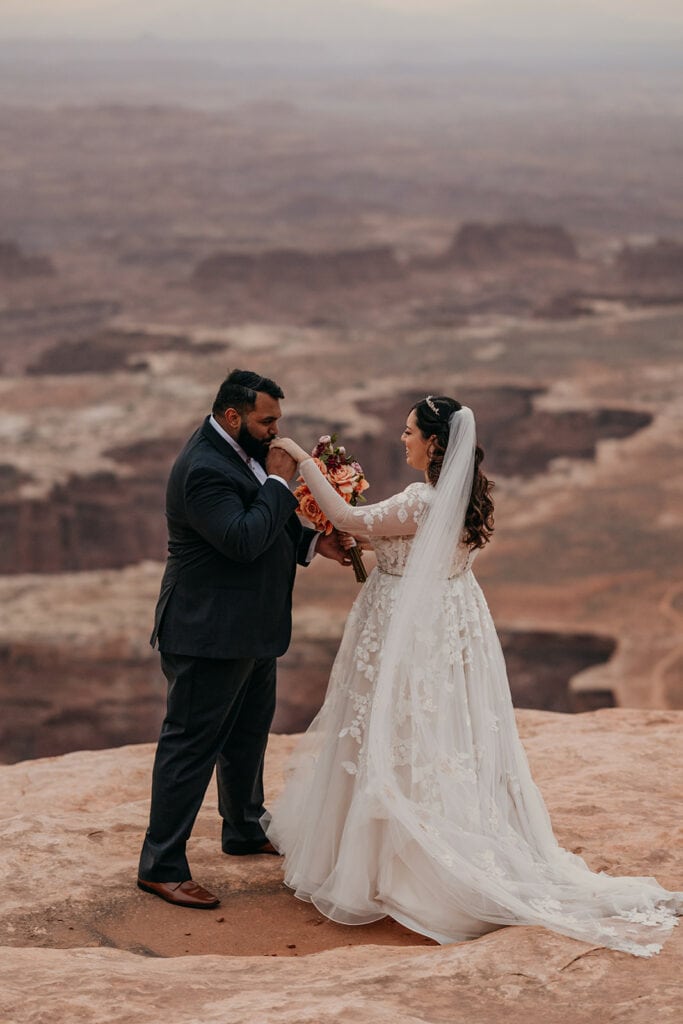 The groom kisses the brides hand after their first look.