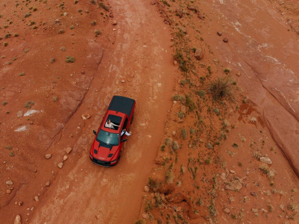 A bride waves to the drone outside of Canyonlands National Park