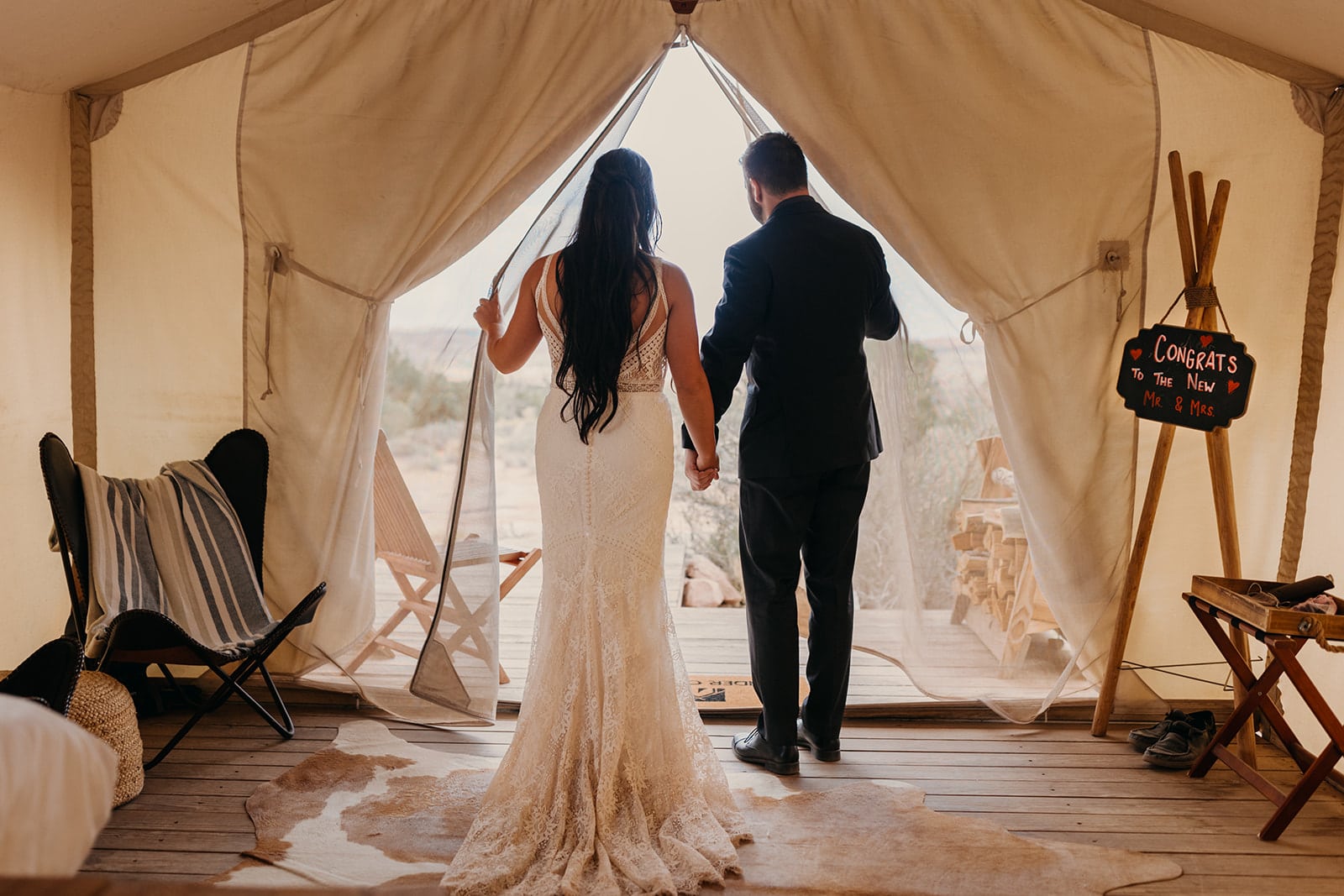 A couple walks out of their glamping tent at under canvas to start their wedding day.