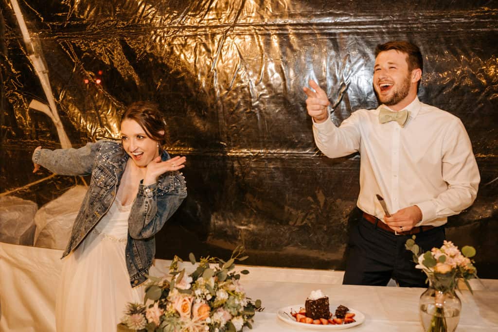 A bride and groom smiling in celebration at their reception.
