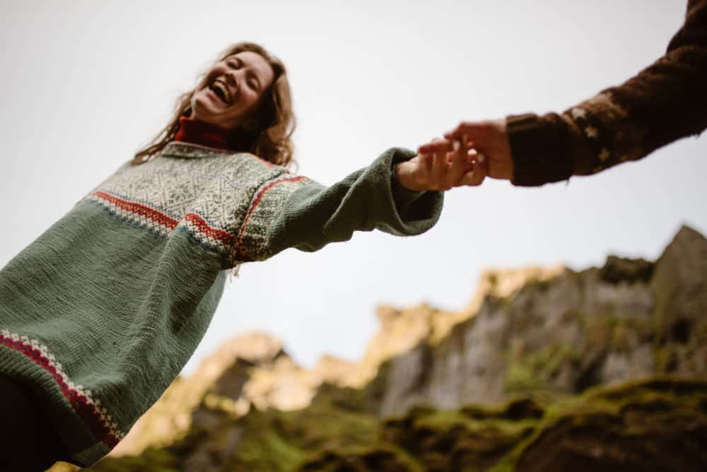 A girl smiles and laughs as the camera looks up at her. 