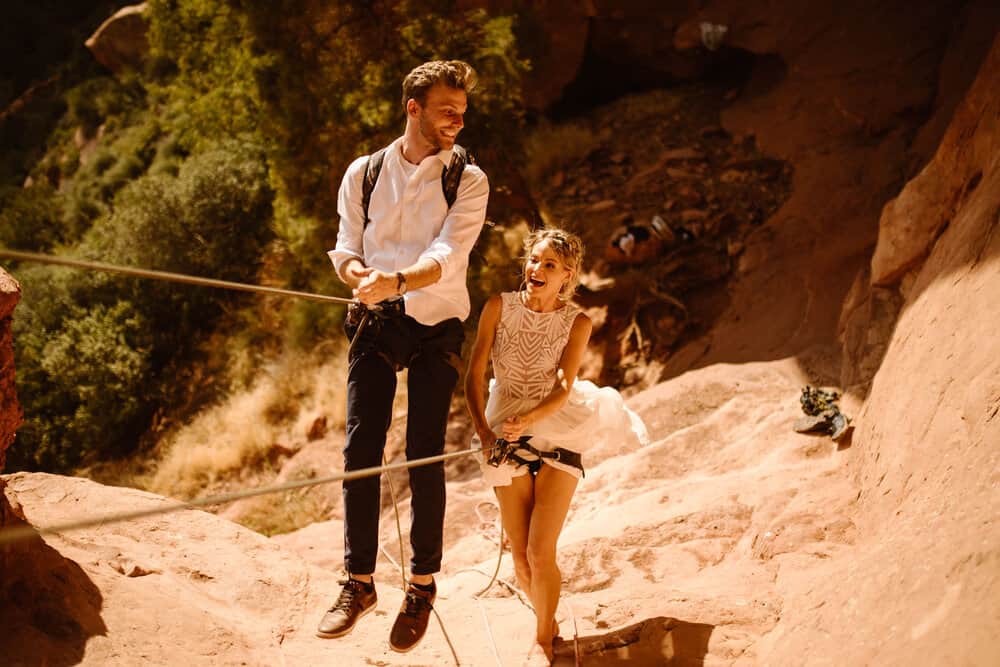 A couple plays around on ropes as they rappel together.