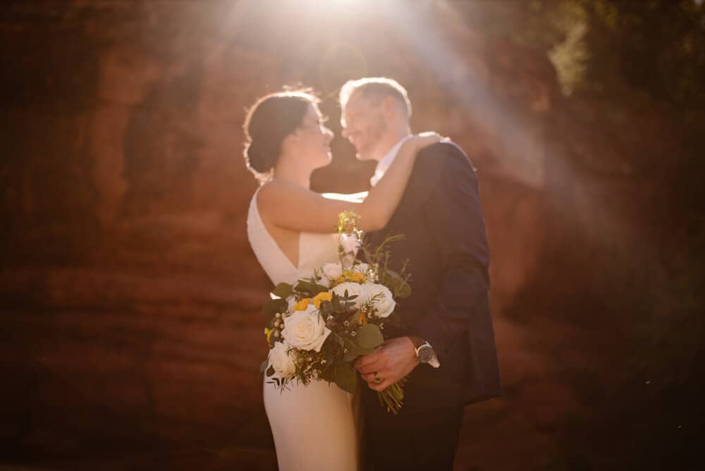 A detail photo of the brides flowers as the groom holds them.
