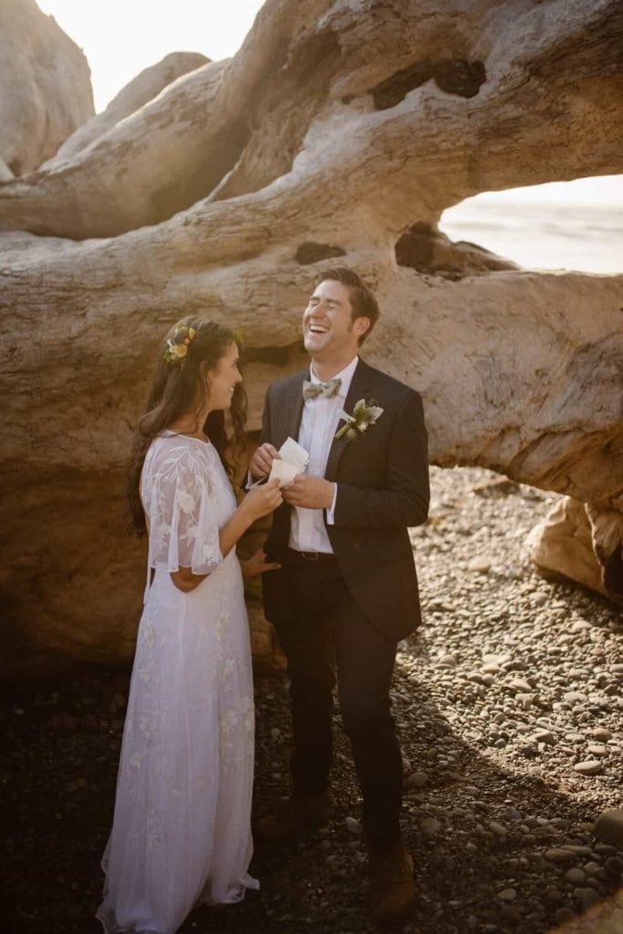 A groom laughs as he listens to his brides vows.
