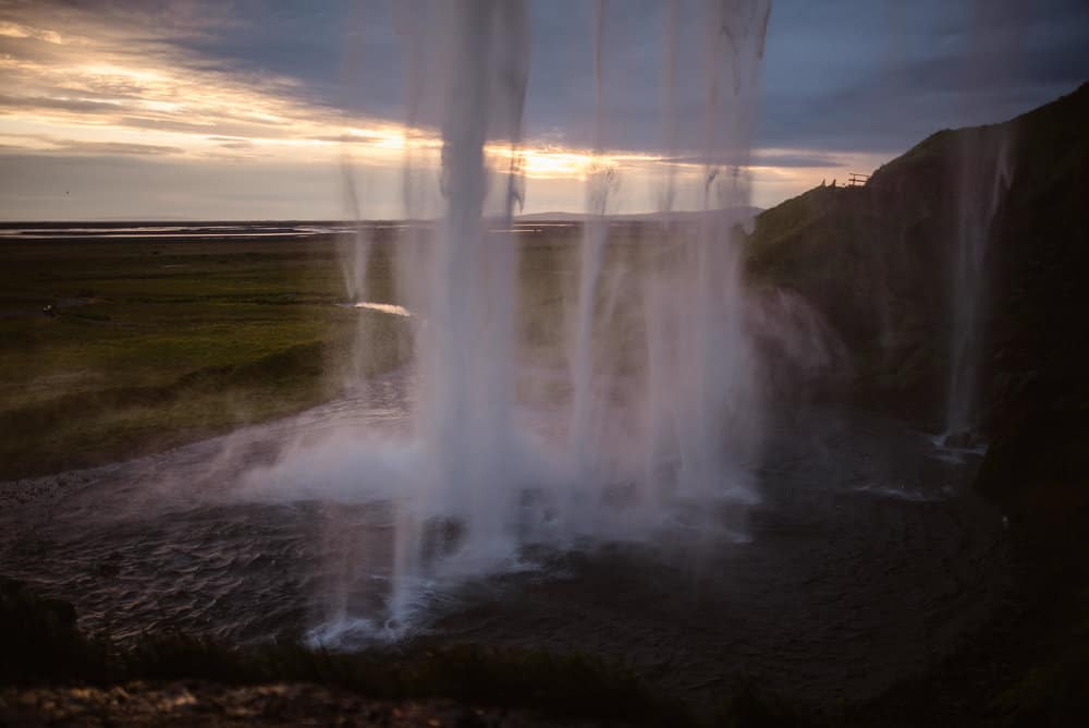 Seljalandsfoss waterfall in iceland captured from behind the falls.