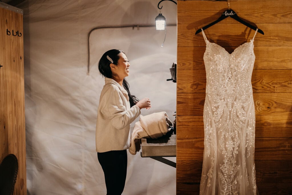 The bride smiles in the mirror as she gets ready.