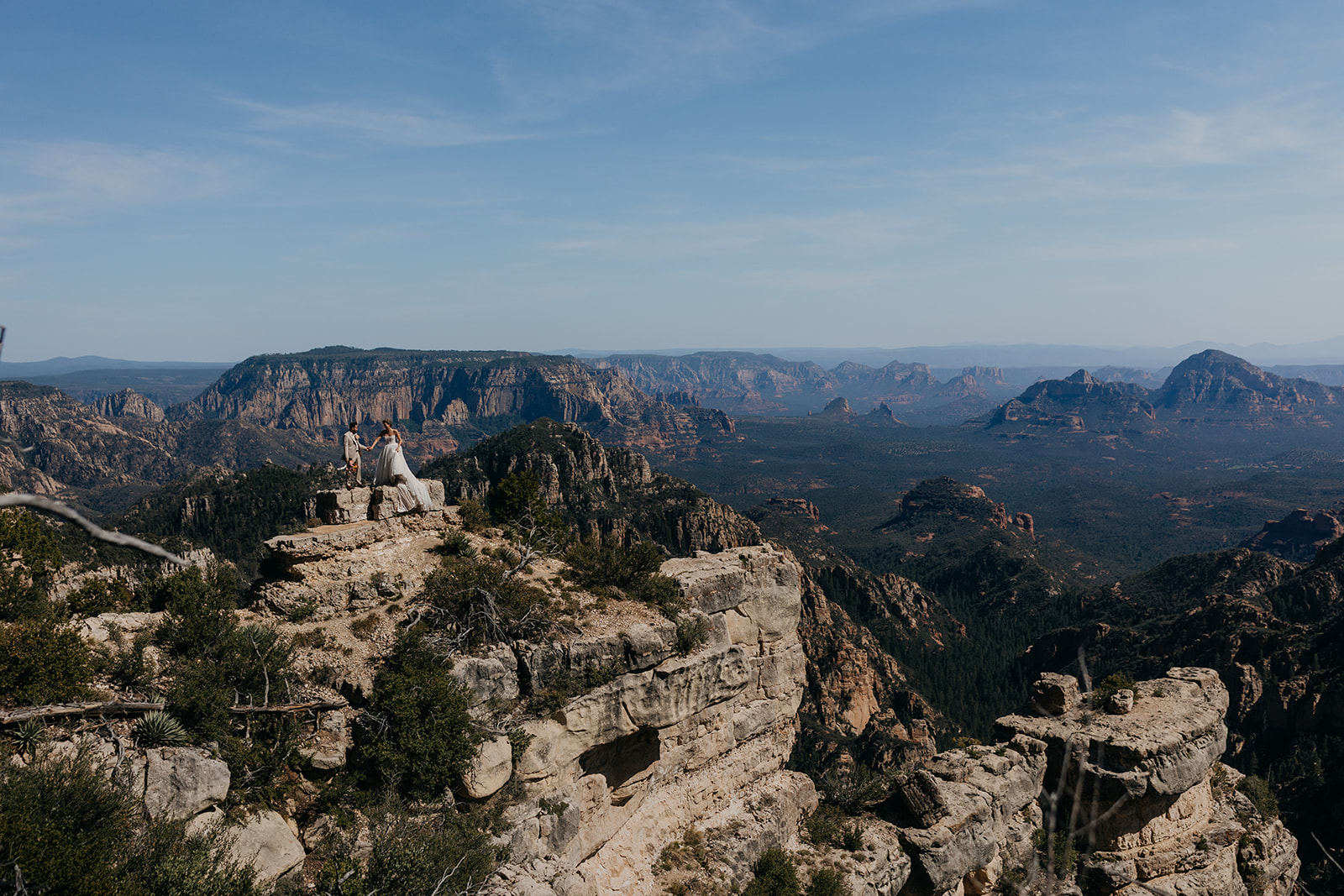 The couple stands for a vista side portrait overlooking Sedona.