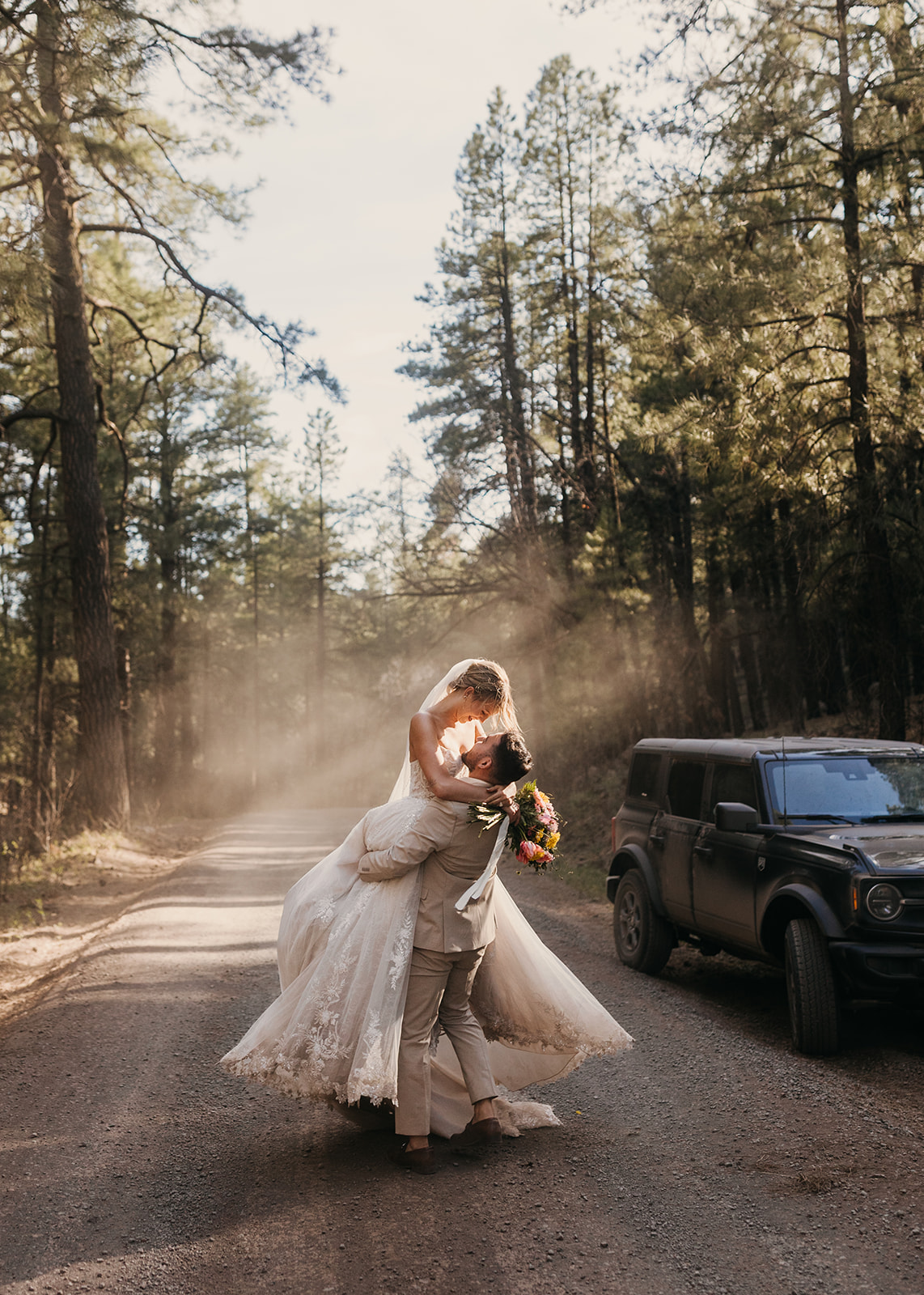 A groom spins his bride on a dusty romantic setting in Flagstaff.