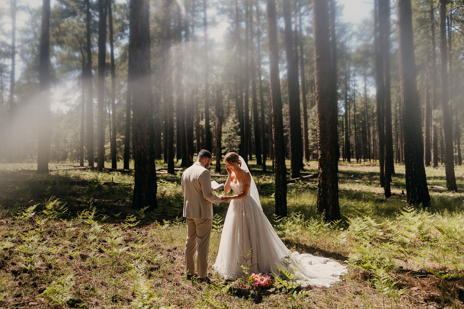 A bride sheds a tear listening to her grooms vows under the pines.