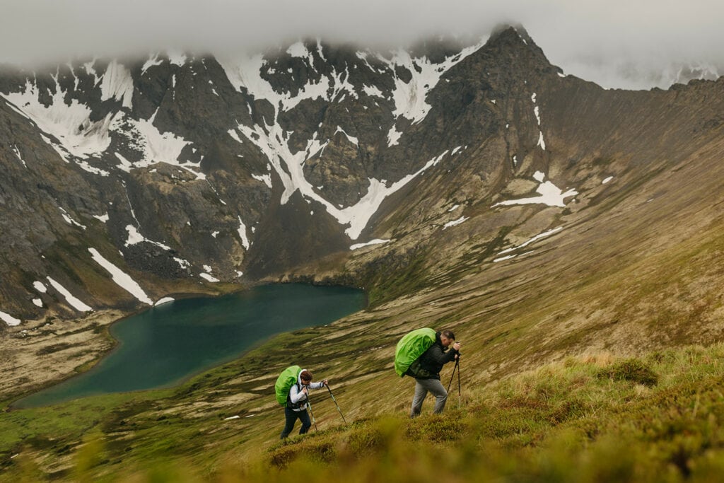 The bride and groom hike out of the steep trail.
