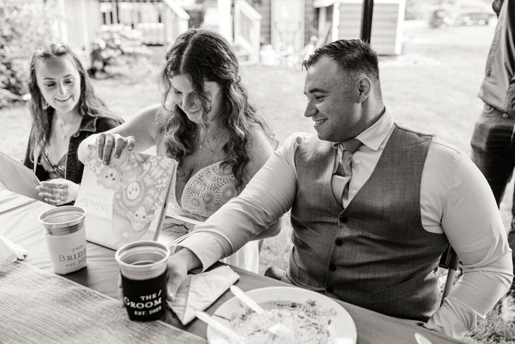 The bride looks at the gift the dad gave the couple.
