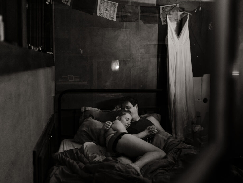 A couple cuddles in bed together before their elopement day.