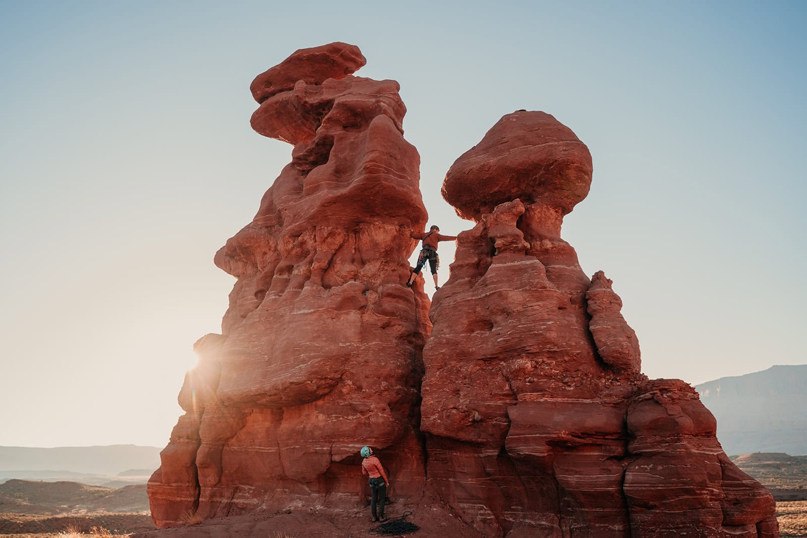 A couple rock climbing a route in Moab