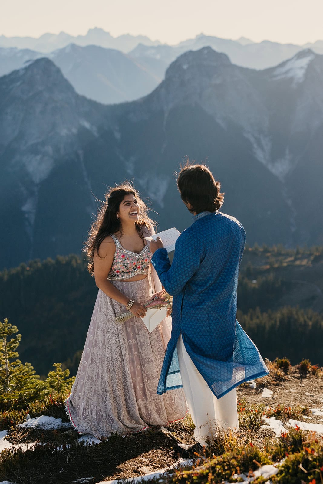 A bride wears a traditional Indian wedding dress during her vows in the mountains.