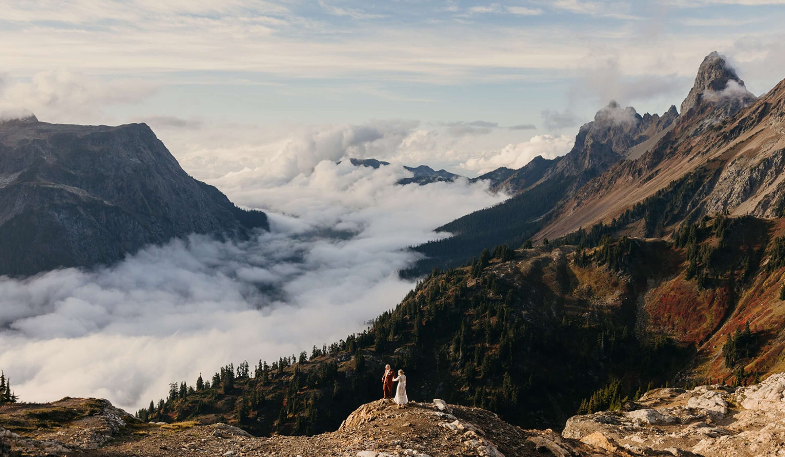 A couple stands in awe of the cloud inversion in the Mt Baker National Forest.