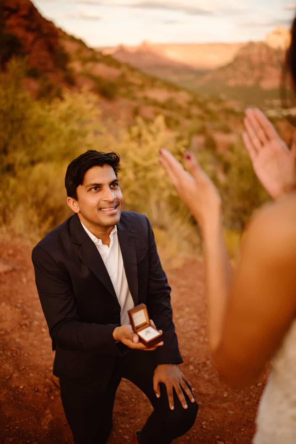 A man drops to one knee as he proposes to his future wife.