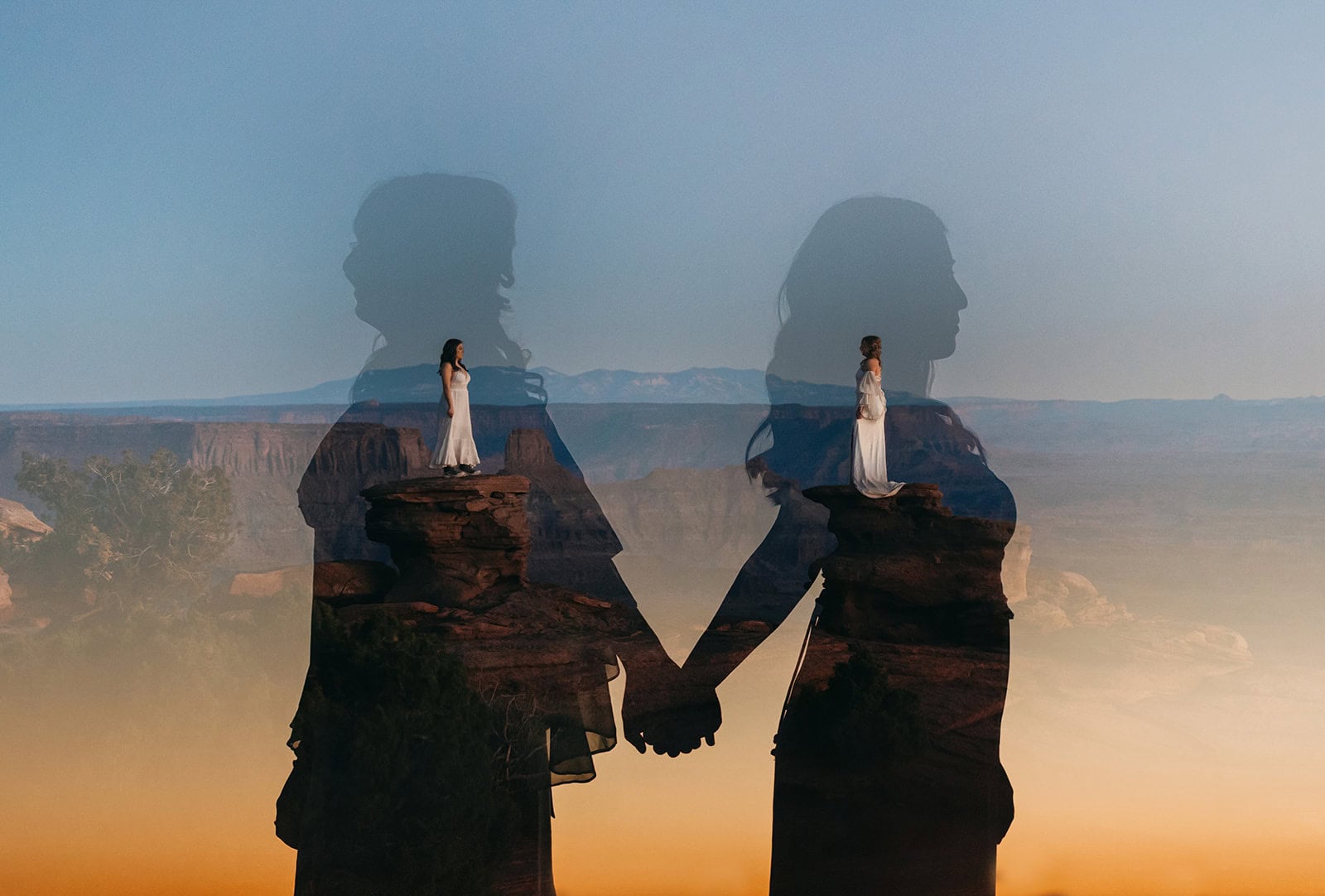 Two brides hold hands in the dusk lighting at Dead Horse Point State Park.