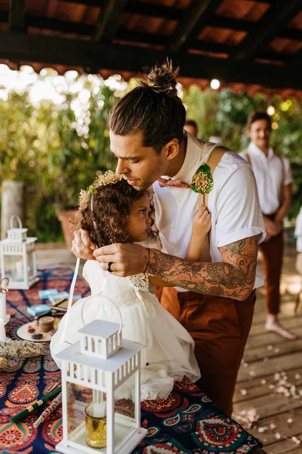 The groom gives his daughter a necklace during their wedding ceremony.