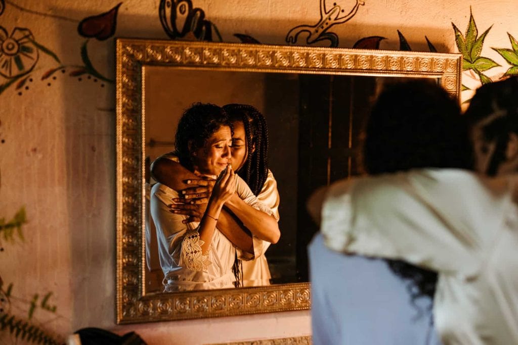 The bride's friend hugs her as they get ready on this emotional day.