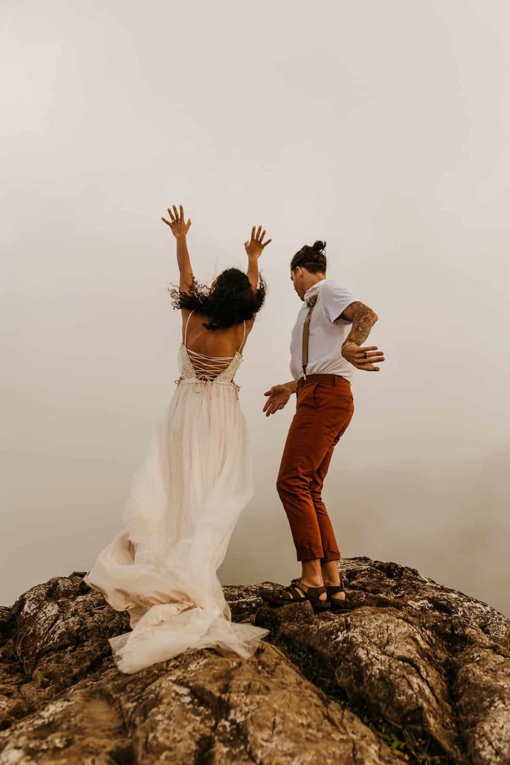 A couple does a rain dance in hopes that the clouds will clear so they can see the view. 