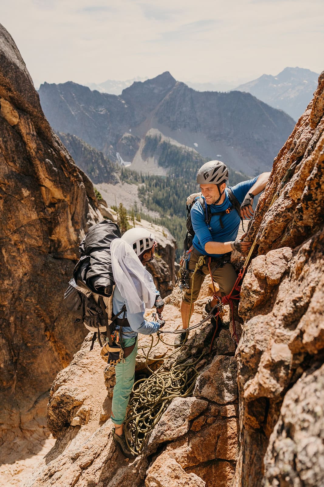 A bride and groom getting ready to begin a climb in the mountains