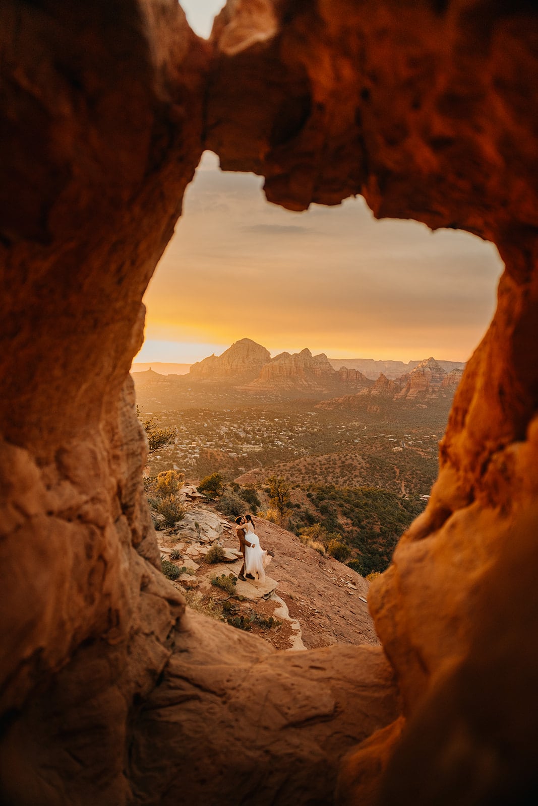 A couple stands on a vista at sunset in Sedona at the end of their elopement day.